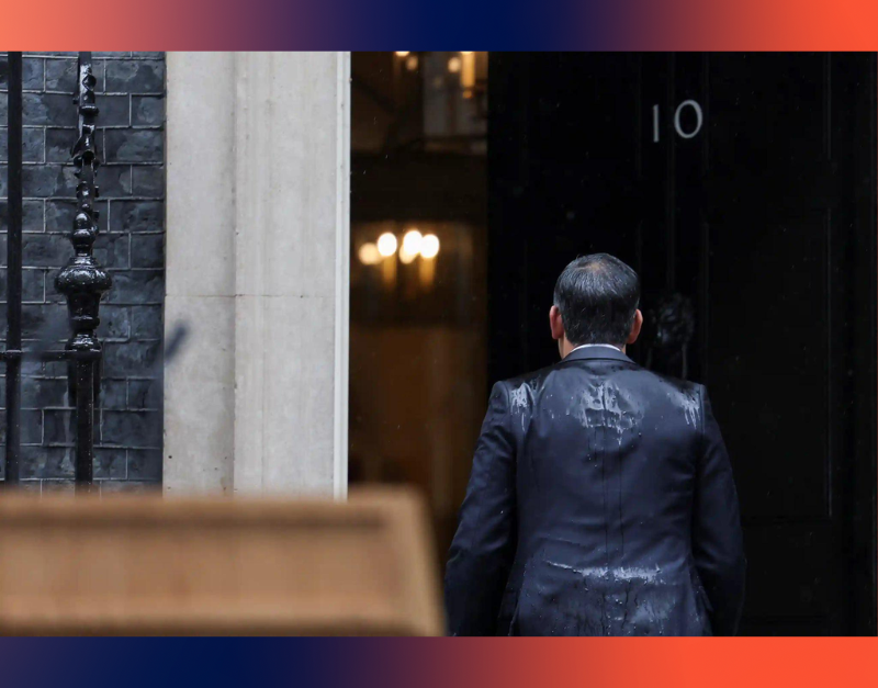 A photo of a rain-drenched Rishi Sunak walking into 10 Downing Street.